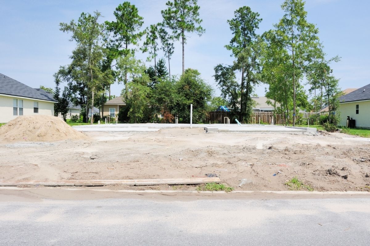 A concrete slab with trees behind on a new home construction site in South Florida.