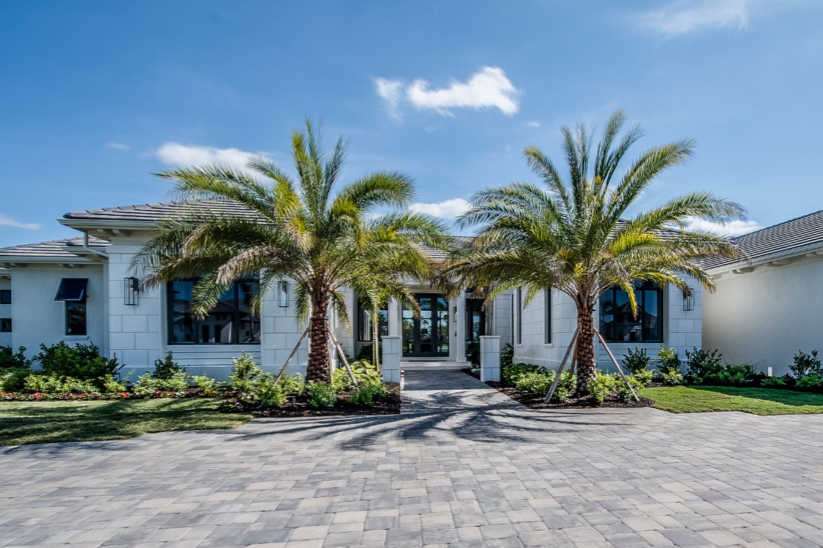 Newly planted palms frame the entryway of this South Florida home.