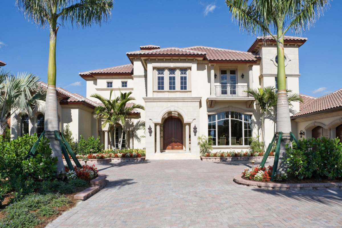 Large, newly planted royal palms on either side of this South Florida driveway.